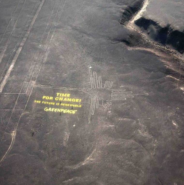Greenpeace activists stand next to massive letters delivering the message "Time for Change: The Future is Renewable," next to the hummingbird geoglyph in Nazca in Peru, Monday, Dec. 8, 2014. Greenpeace activists from Brazil, Argentina, Chile, Spain, Germany, Italy and Austria displayed the message, which can be viewed from the sky, during the climate talks in Peru, to honor the Nazca people, whose ancient geoglyphs are one of the country's cultural landmarks. (AP Photo/Rodrigo Abd)